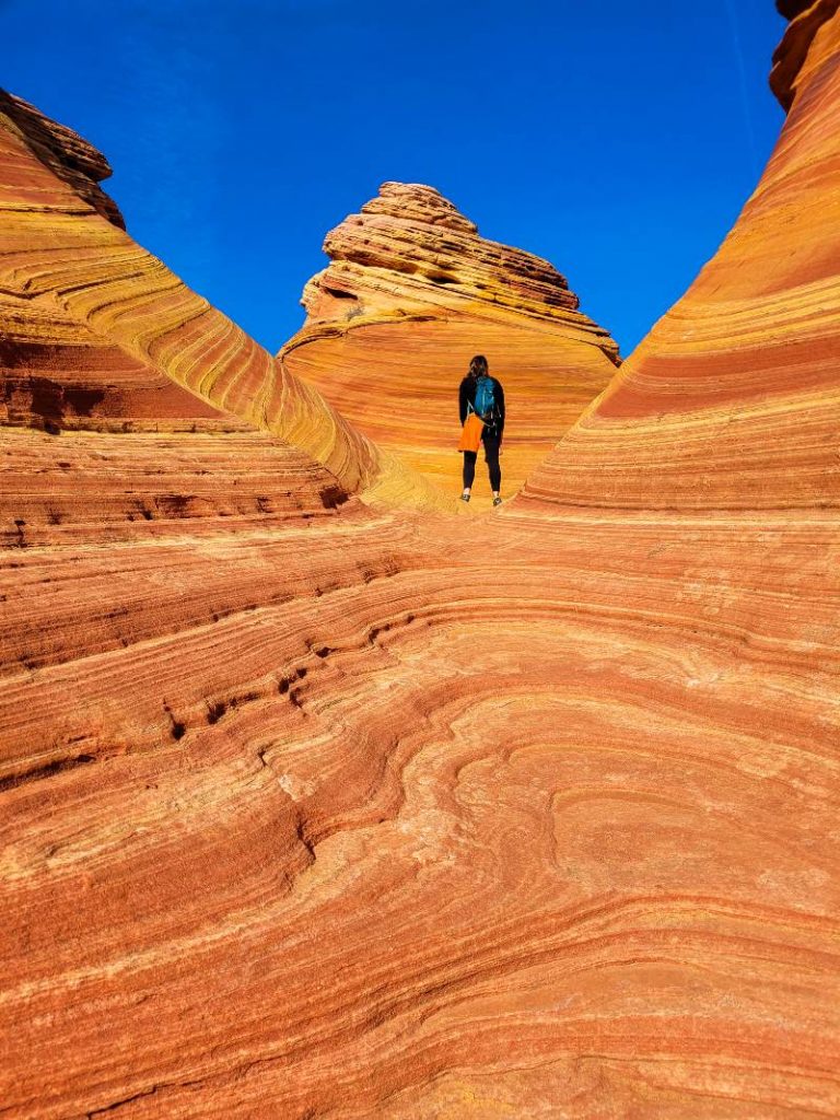 A woman who won The Wave Arizona lottery standing in one of the rock formations