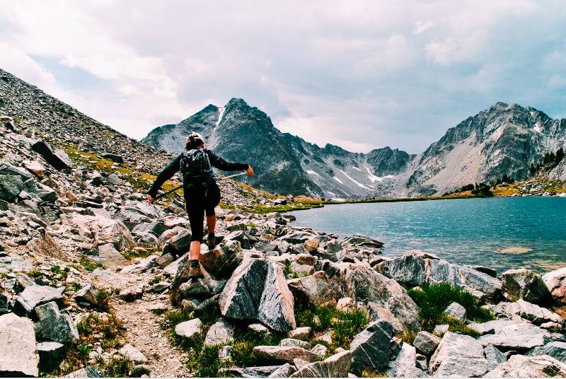 A woman hiking near the shore of Summit Lake, one of the best hikes in Big Sky Montana