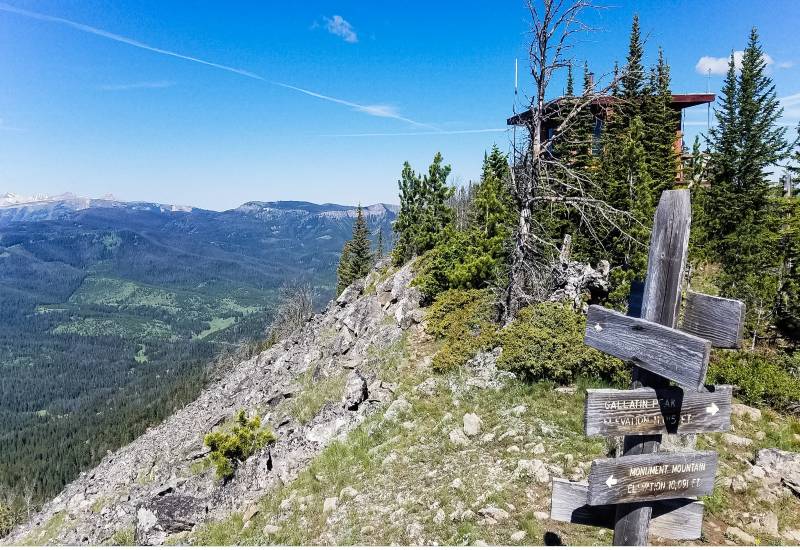A wooden sign and the fire lookout at Cinnamon Mountain, one of the best Big Sky hikes