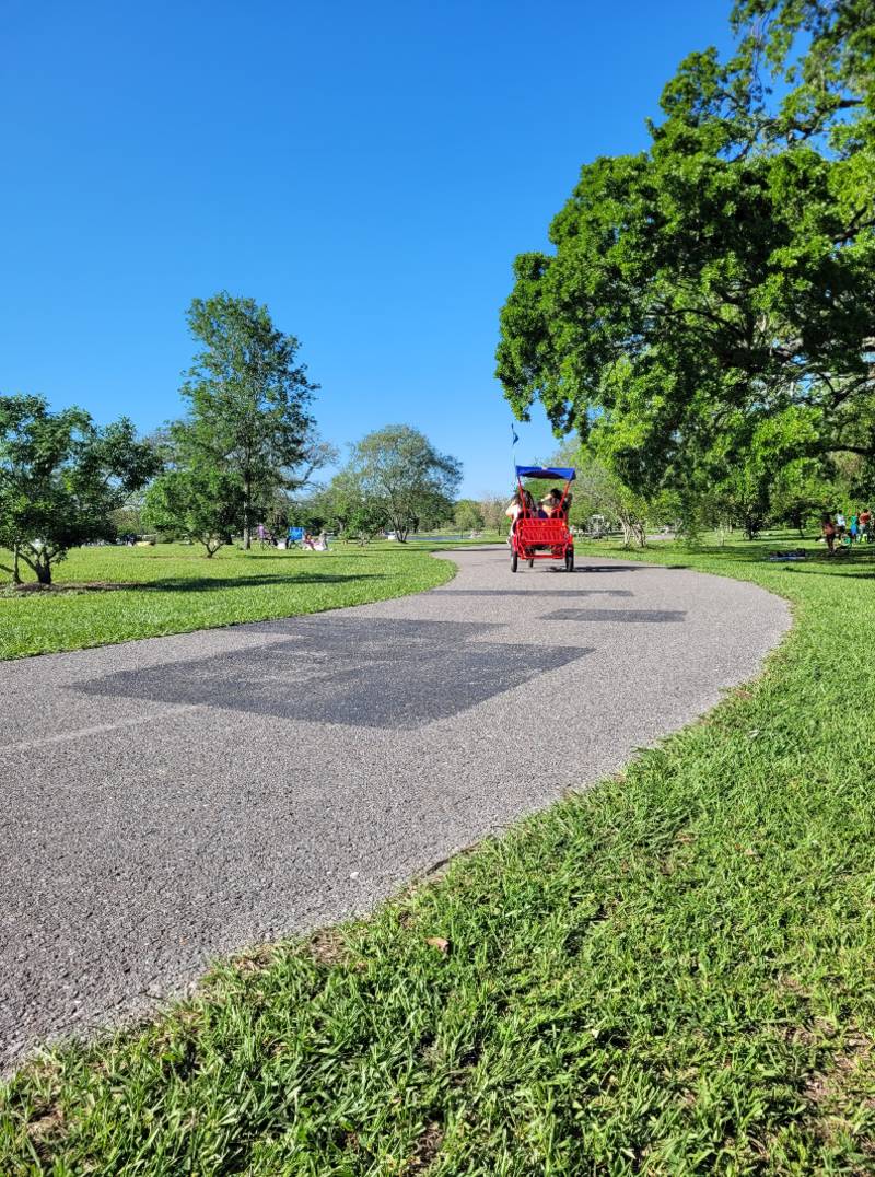 A red surrey in City Park, which is one of the best New Orleans outdoor activities to enjoy