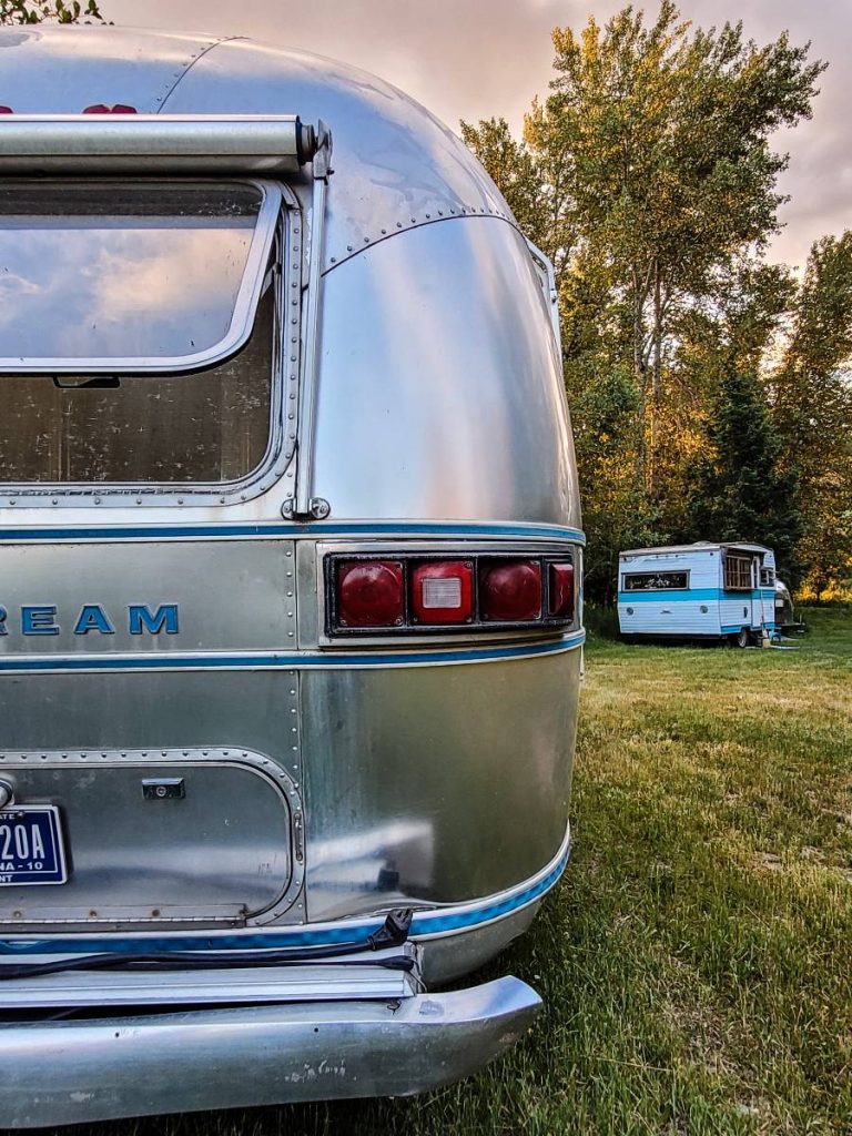 The back of an Airstream and another vintage trailer in the background at Tobacco River Ranch, a Montana glamping resort