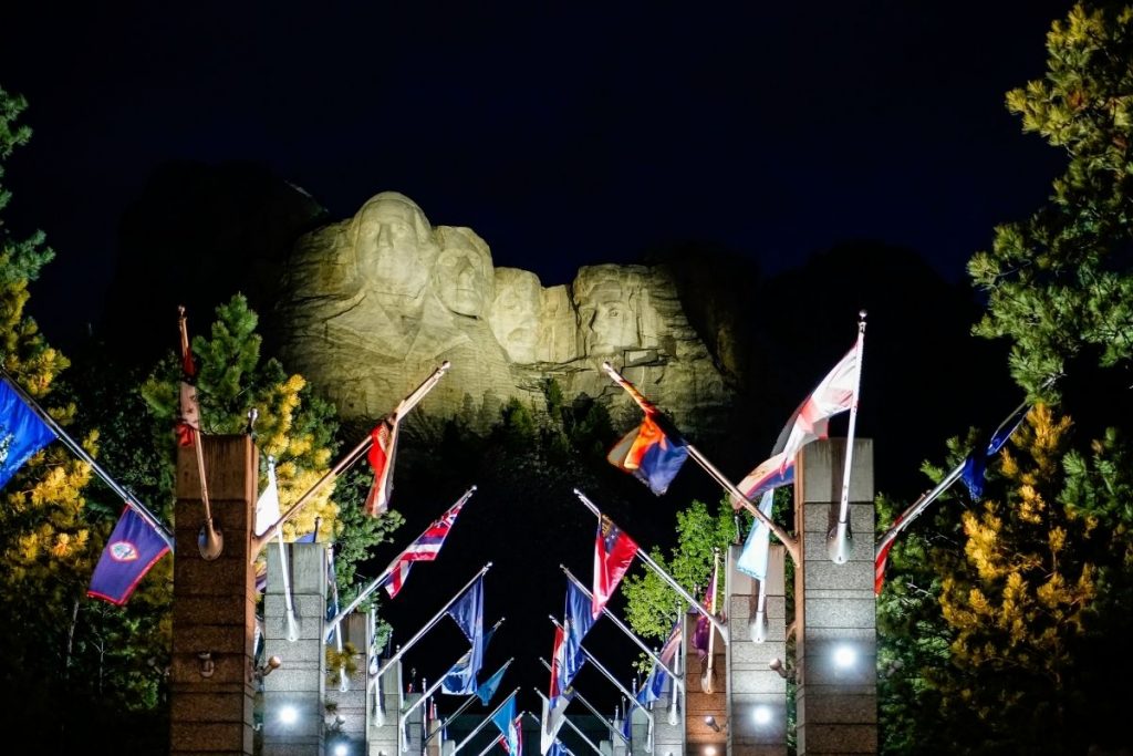 The nighttime presentation at Mount Rushmore, with the presidents' faces illuminated up above and the Avenue of Flags in the foreground
