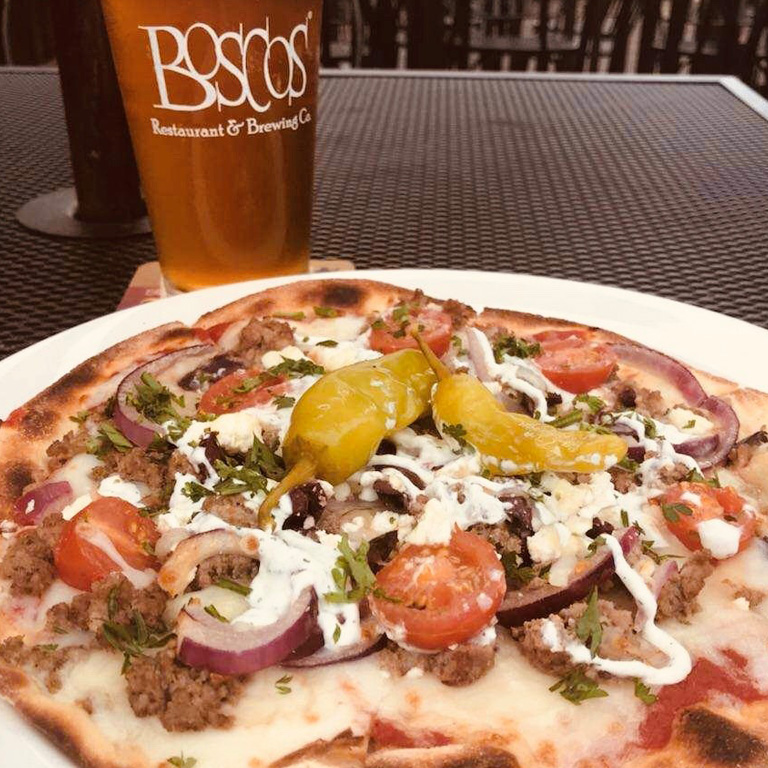 A pizza with a mug of beer behind it at Bosco's Restaurant, one of the first Memphis breweries