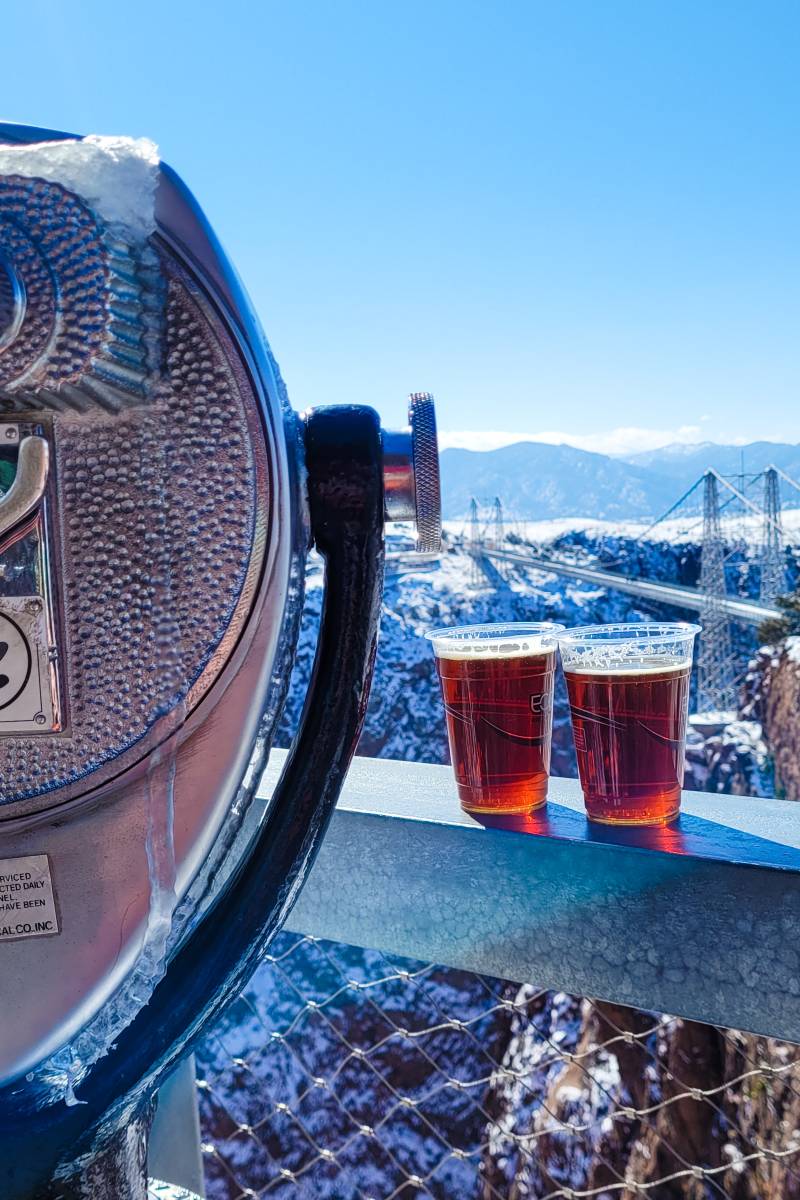 A tower viewer and two beers on a ledge overlooking the Royal Gorge Bridge