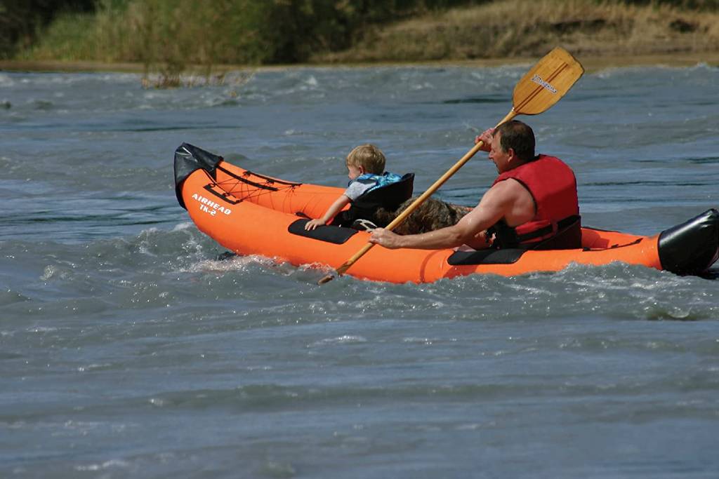 An adult and child kayaking in an Airhead Montana orange inflatable kayak