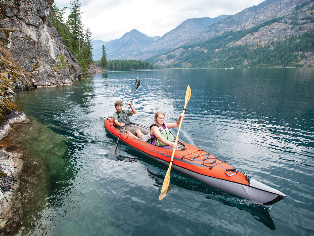 A male and female paddling an Advanced Elements Advanced Frame kayak in a mountain lake