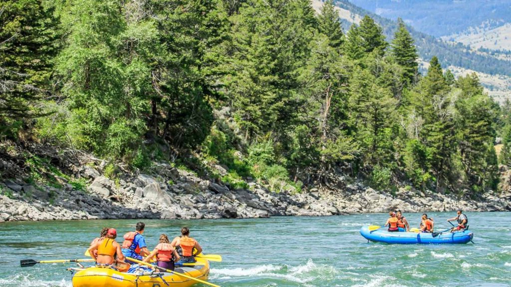 Two groups of rafters experiencing Yellowstone white water rafting on the river
