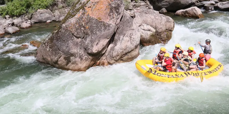 A yellow raft of people experiencing Yellowstone white water rafting