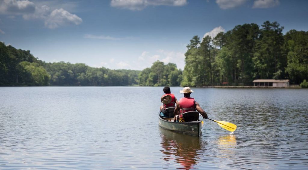 Two people paddling a canoe in Umstead State Park, one of the best outdoor activities in Raleigh NC