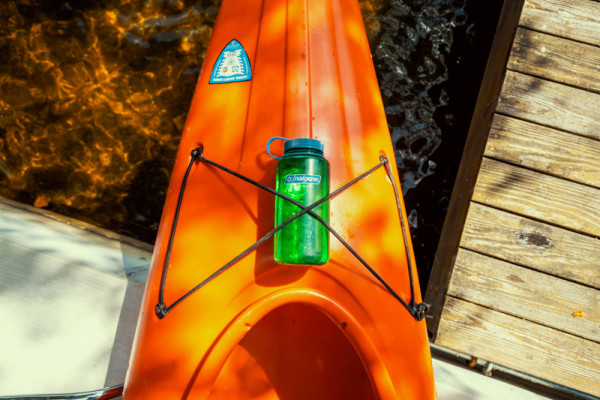 A Nalgene water bottle lashed down to a kayak, both great choices for the best gifts for outdoorsy women