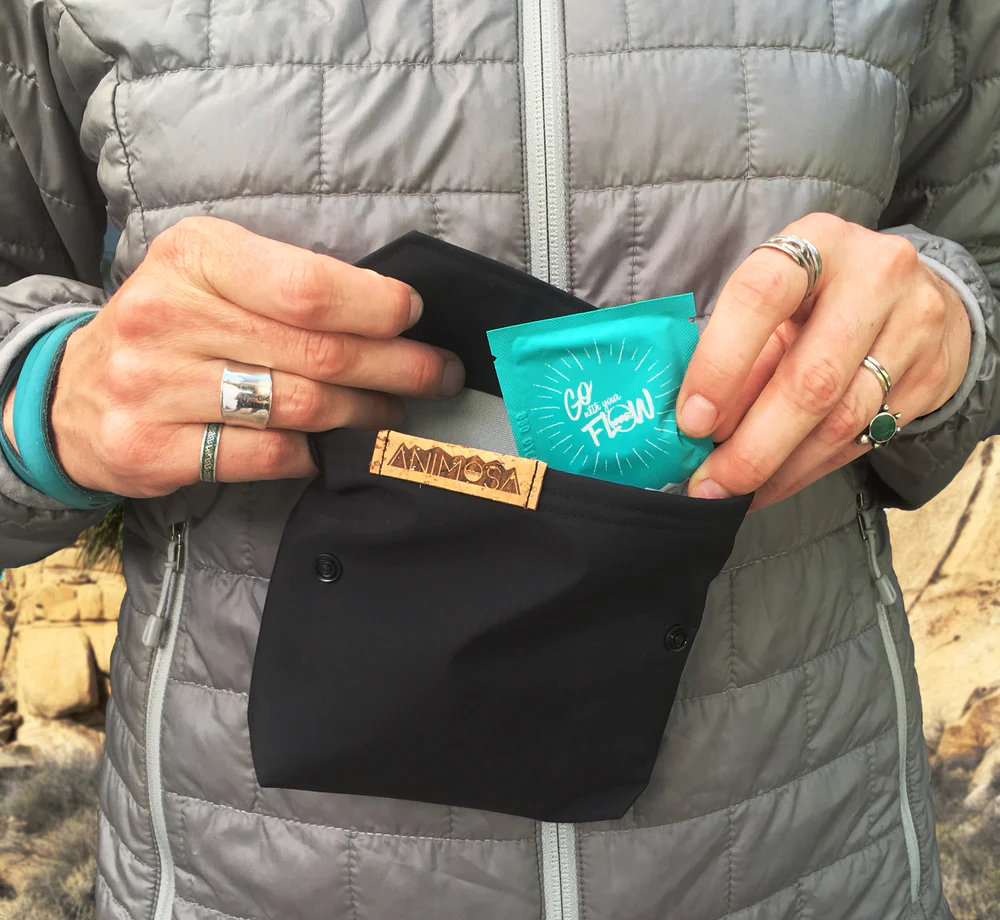 A woman putting items into the Go With Your Flow kit, one of the best gifts for outdoorsy women