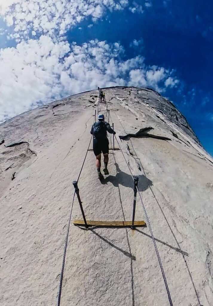 point of view of male hiker climbing the Half Dome cables