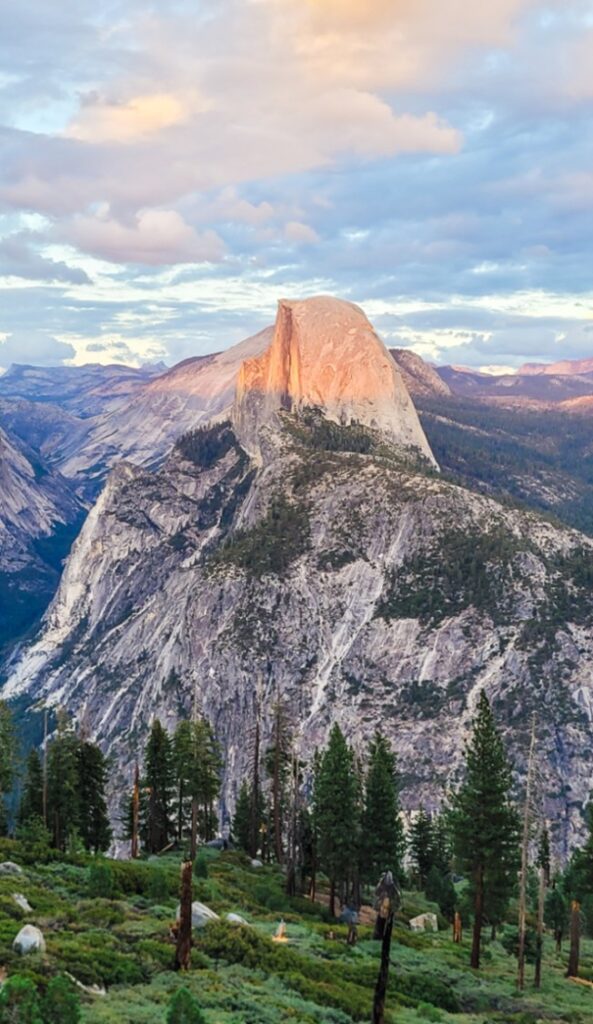 view of half dome with the light of sunset shining down on it