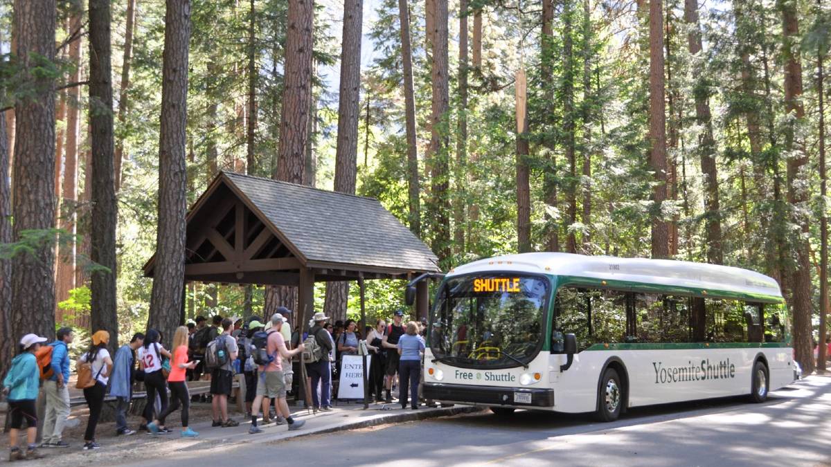 view of shuttle bus picking up people at the happy isies shuttle stop near half dome