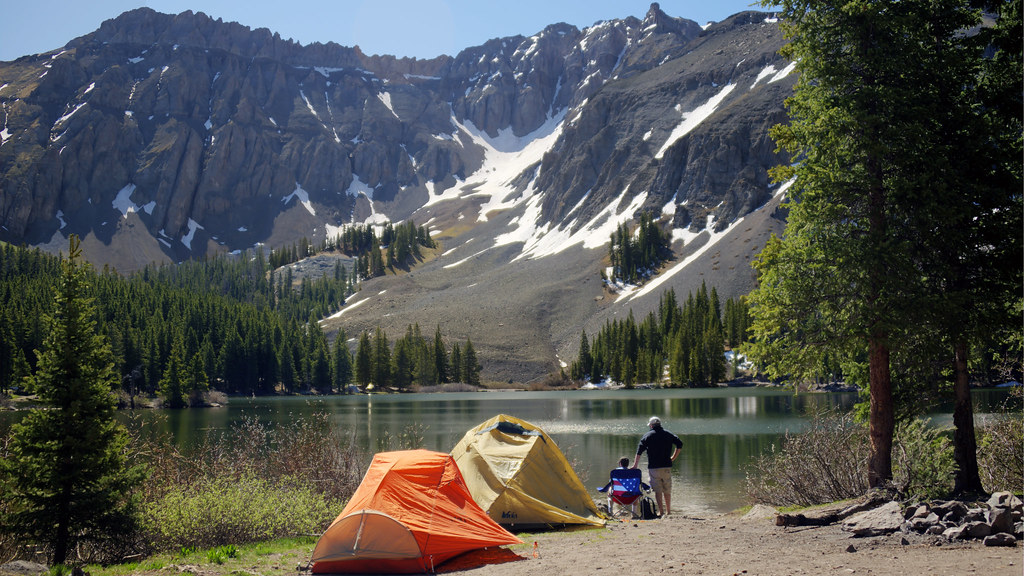 Two tents set up along the shores of Alta Lake, one of the most popular Telluride campgrounds, with two people standing nearby