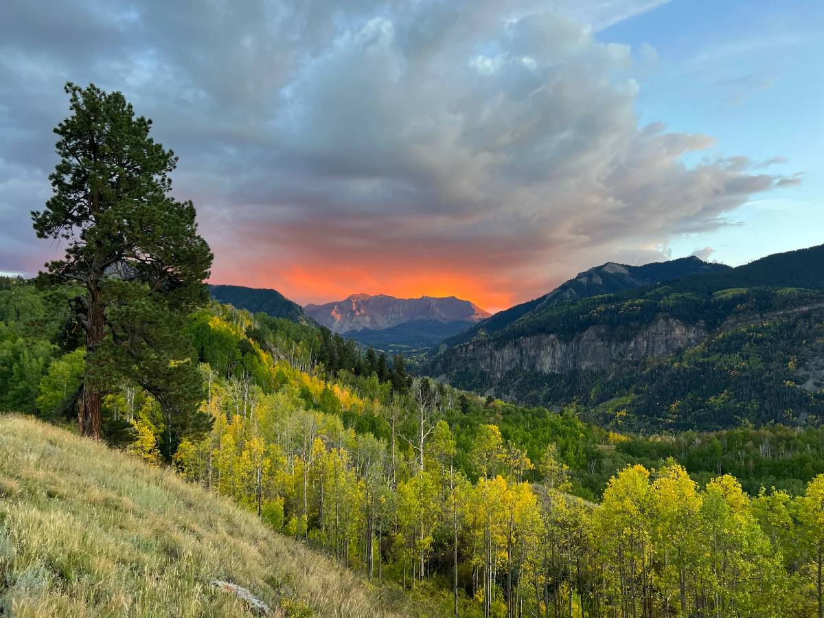 An orange sunset over the mountains, as seen from Sunshine Campground, a campsite near Telluride