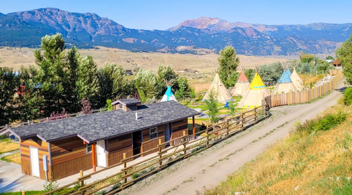 view of field and tipis along with the bath house at yellowstone glamping property