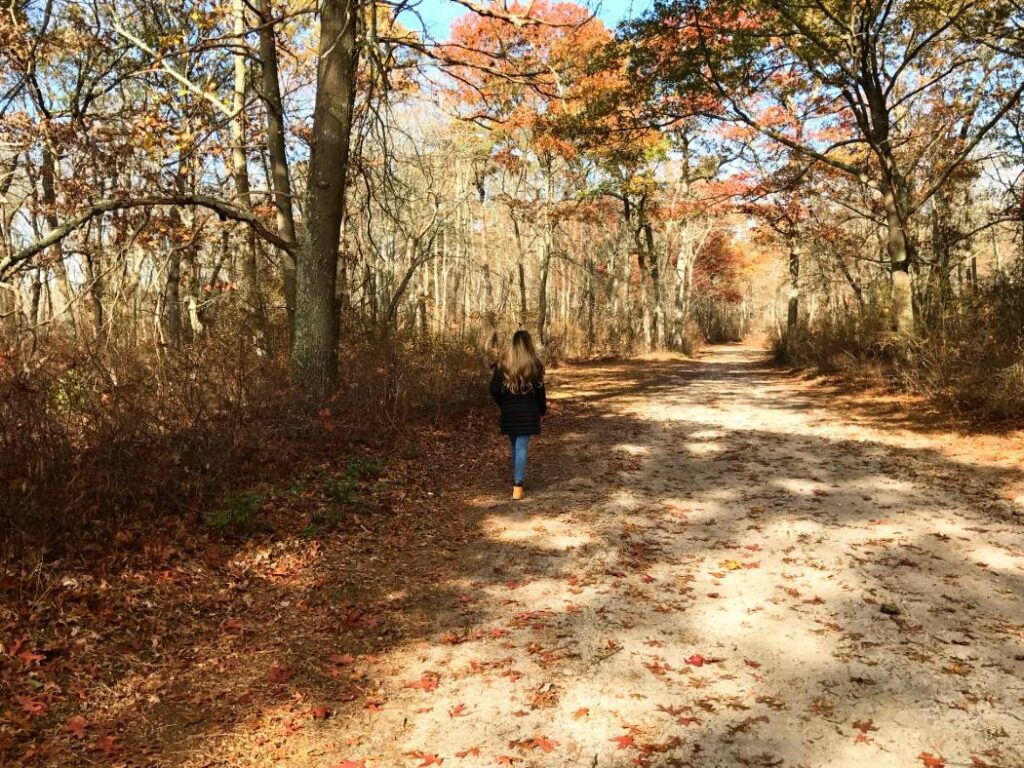 A woman walking along a path in Connetquot River State Park Preserve