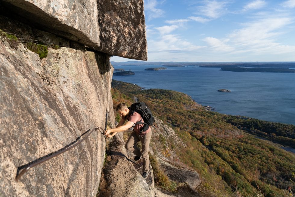 A man using an iron wrung on the Precipice Trail in Acadia National Park, one of the best East Coast hikes