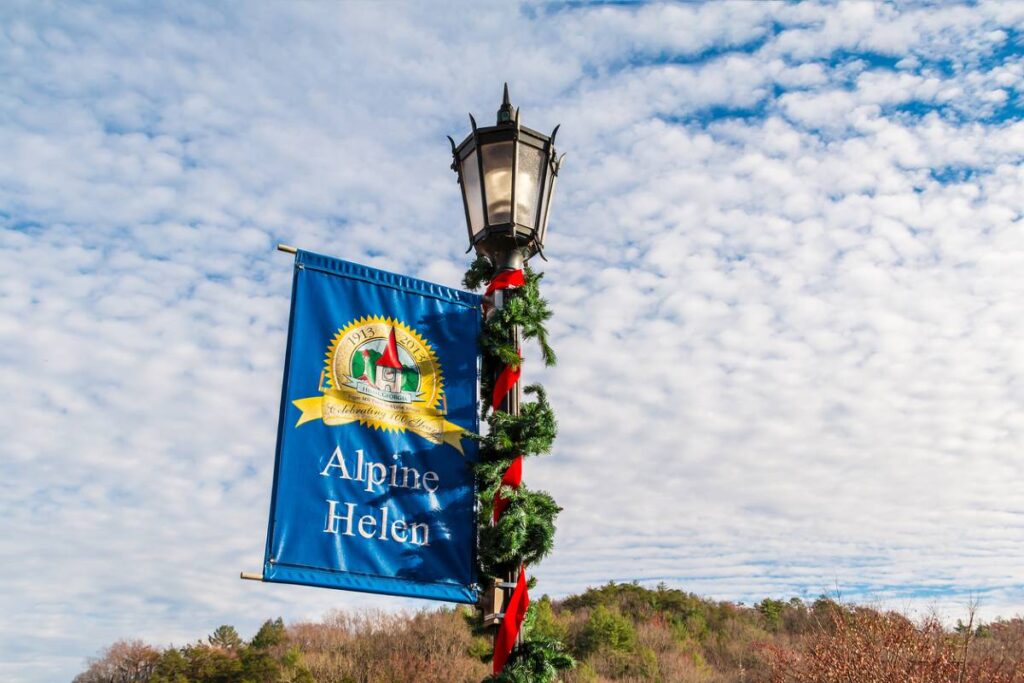 A street lamp decked out in holiday decor spotted in Helen Georgia at Christmas, in front of a blue sky