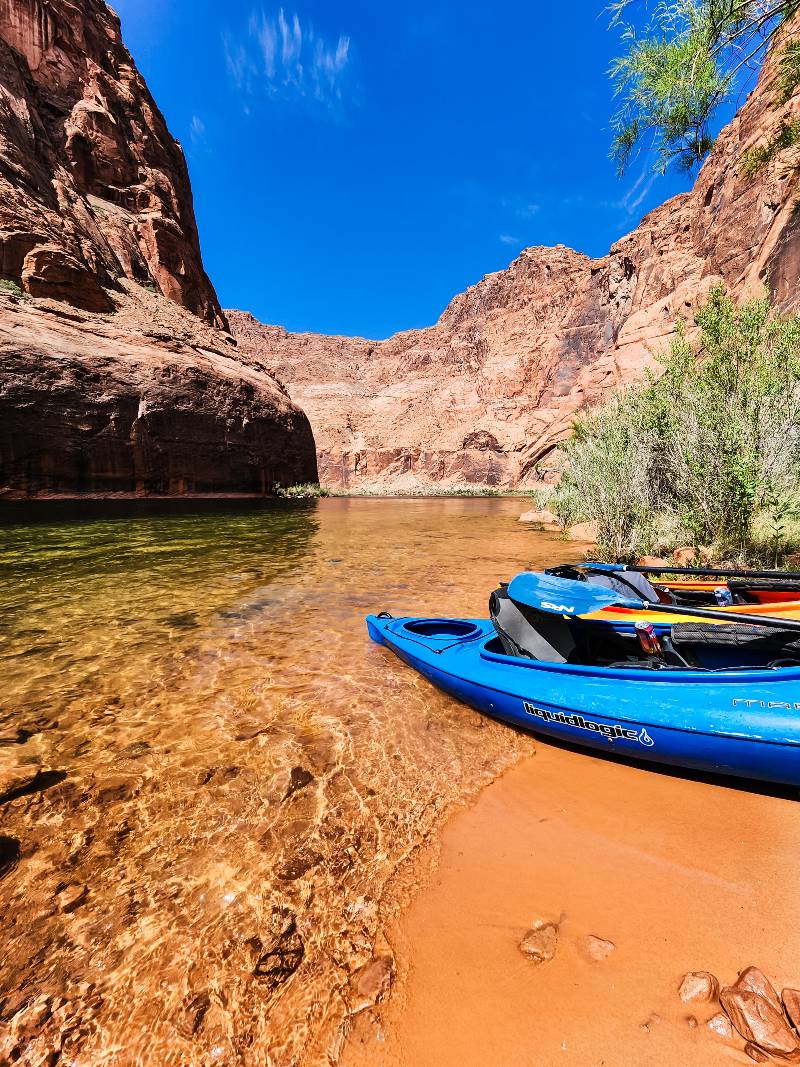 Two kayaks tethered together on a sandy beach during a Horseshoe Bend kayaking trip