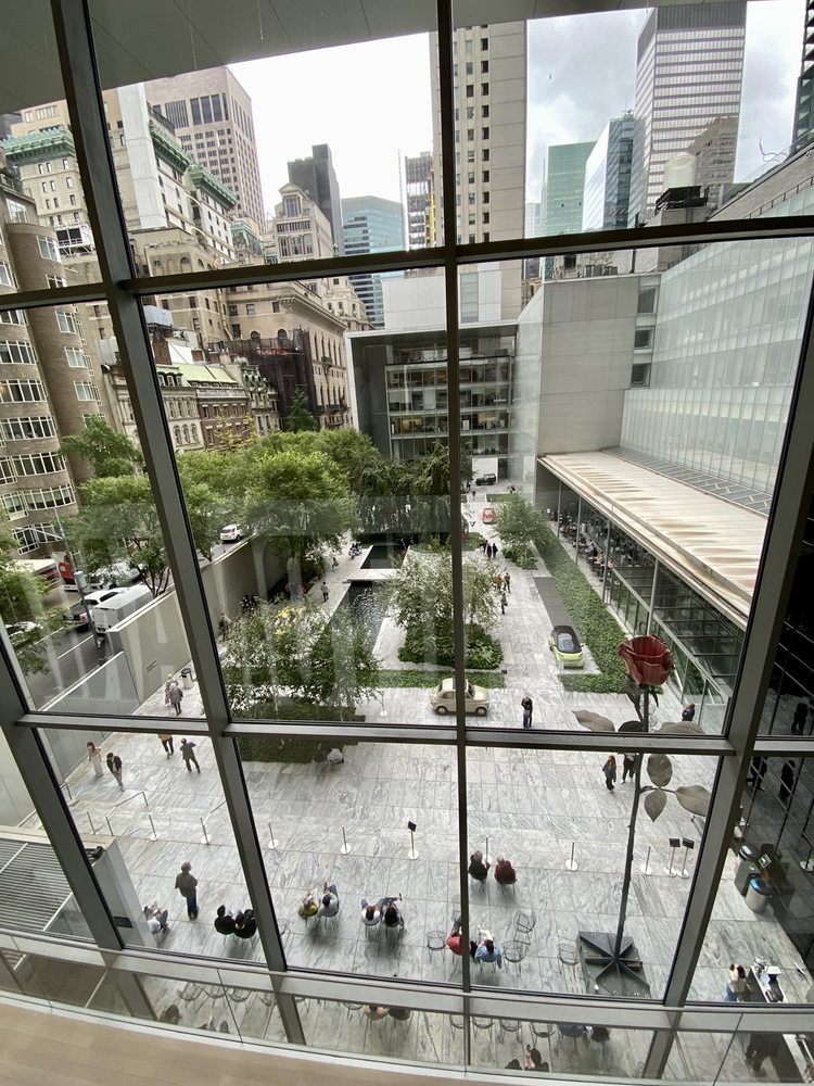 A view through a window of the Abby Aldrich Rockefeller Sculpture Garden at MoMA in NYC