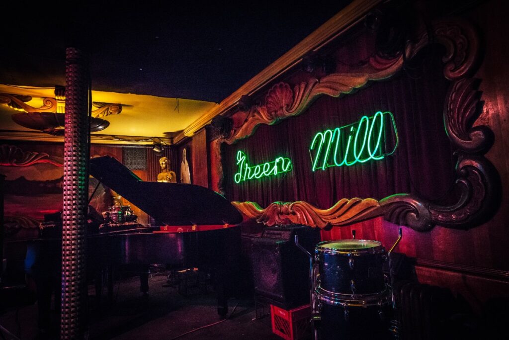 The stage and iconic green neon sign at the Green Mill, a jazz club popular for Chicago winter date ideas