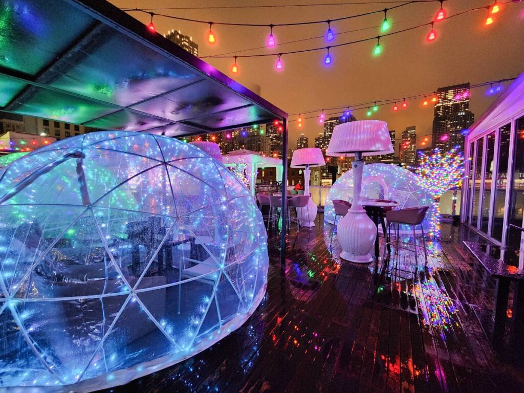 Igloos, heaters, and colorful lights on i|O Godfrey, the Chicago winter rooftop bar at The Godfrey Hotel